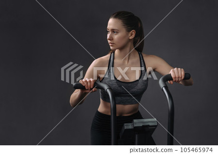 Sporty girl doing exercises on air bike Sporty girl doing exercises on air bike 105465974