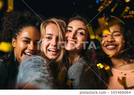 Four laughing girls taking selfie under confetti at night Four laughing girls taking selfie under confetti at night 105466064