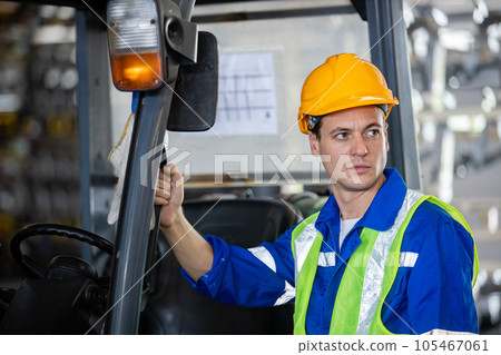 Man wear safety helmet stand beside forklift warehouse in factory. Male worker industrial operate.\ 105467061