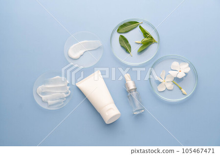 Natural skincare product in laboratory. Cosmetic smears cream texture on glass watch with lotion tube, essential oils bottle and herbal extract. Beauty cosmetic research and development concept. 105467471