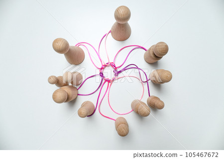 A round knot of threads unites the wooden figures A round knot of threads unites the wooden figures 105467672