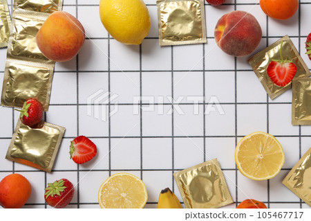Condoms with fruit on a light background in a cell, place for text 105467717