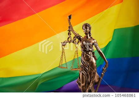 The blindfolded goddess of justice Themis against the rainbow flag of LGBT. LGBT rights and law. 105468861