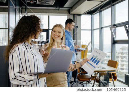 Happy business colleagues using laptop discussing idea 105469325