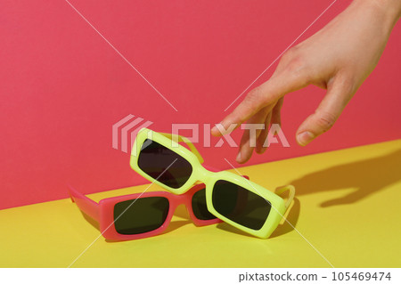 A pair of sunglasses on a bright, colorful background A pair of sunglasses on a bright, colorful background 105469474