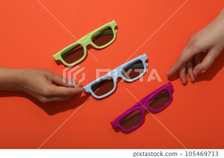 Sun-protective, colored glasses on a bright orange background 105469713