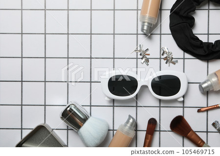 Sunglasses with women's accessories on a checkered background 105469715