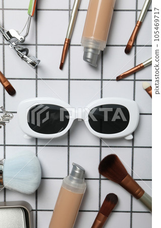 Sunglasses with women's accessories on a checkered background Sunglasses with women's accessories on a checkered background 105469717