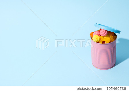 Jelly candies in purple tin on blue background, space for text Jelly candies in purple tin on blue background, space for text 105469786