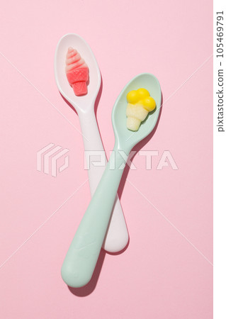 Jelly candies in spoons on pink background, top view 105469791