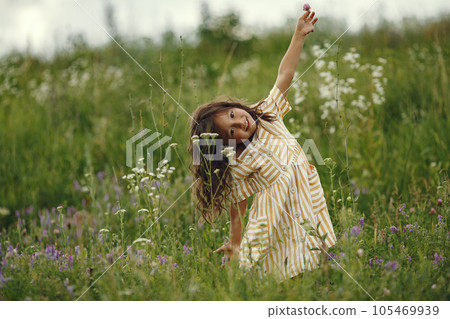 Child in a summer field. Little girl in a cute dress. Child in a summer field. Little girl in a cute dress. 105469939