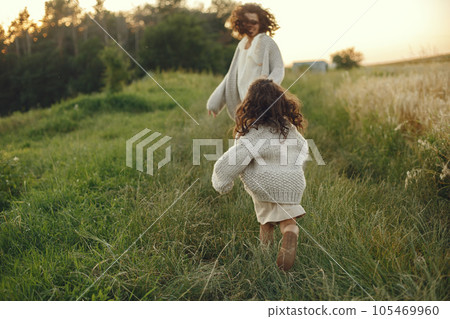 Family in a summer field. Sensual photo. Cute little girl in a knited sweater. 105469960