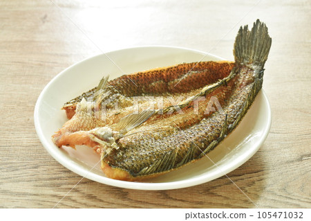 deep fried striped snake head fish with salt on plate deep fried striped snake head fish with salt on plate 105471032