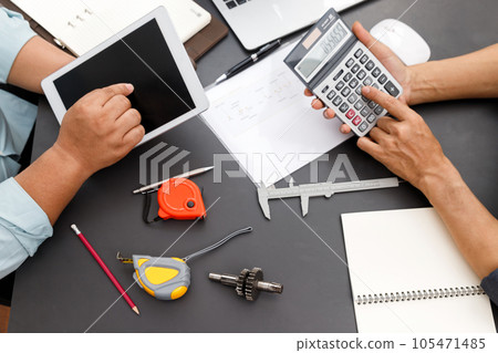 The engineering team is working on their project together. The engineering team is working on their project together. 105471485