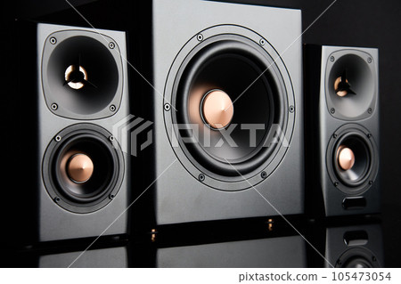 Multimedia acoustic sound speakers. Sound audio system with two satellites and subwoofer on dark background. Stereo system for listening music Multimedia acoustic sound speakers. Sound audio system with two satellites and subwoofer on dark background. Stereo system for listening music 105473054