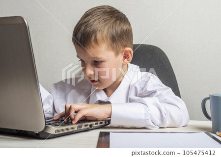 A kid businessman with glasses with laptop working in office 105475412