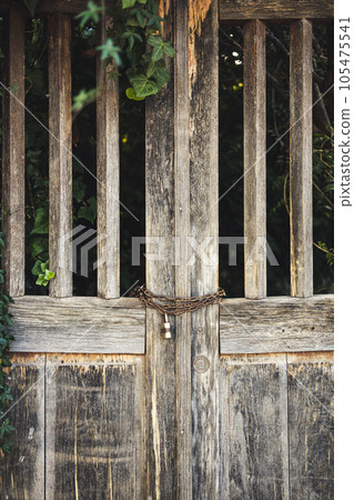 Old wooden gates with a chain lock. Old wooden gates with a chain lock. 105475541