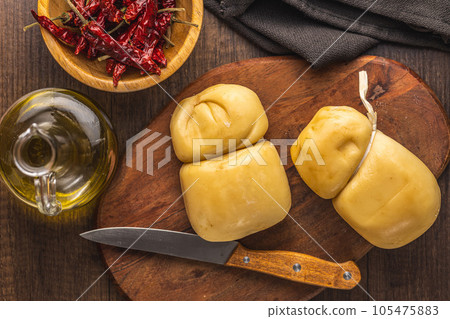 Smoked scamorza cheese on cutting board. Top view. 105475883
