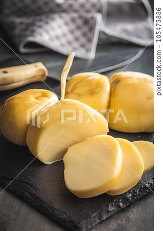 Smoked scamorza cheese on cutting board. 105475886