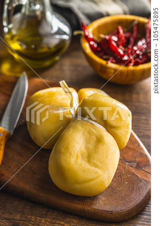 Smoked scamorza cheese on cutting board. 105475895