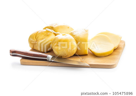 Smoked scamorza cheese on cutting board isolated on white background. 105475896