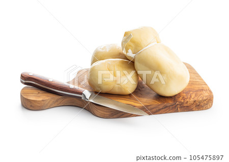 Smoked scamorza cheese on cutting board isolated on white background. 105475897