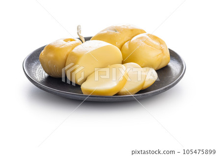 Smoked scamorza cheese on plate isolated on white background. 105475899