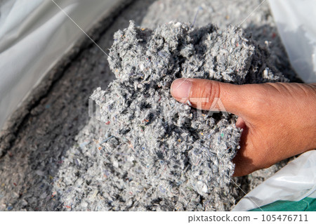 Cellulose insulation for walls and floors In hand. Recycled newsprint. Heat preservation and energy Cellulose insulation for walls and floors In hand. Recycled newsprint. Heat preservation and energy 105476711