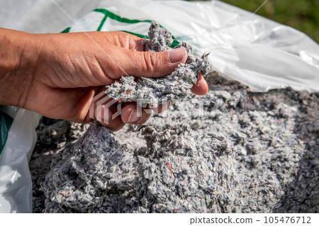 Cellulose insulation for walls and floors In hand. Recycled newsprint. Heat preservation and energy 105476712