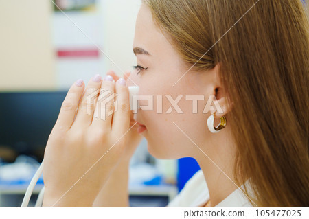 A patient on a magnetotherapy procedure on the nose 105477025