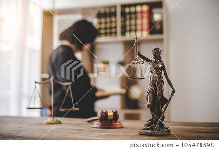 Lady Justice Holding Scales of Law in a Courtroom - Symbolizing Equality, Fairness, and Legal Proceedings 105478398