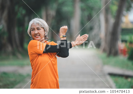 white-haired elderly person exercising in the park early in the morning. 105478413
