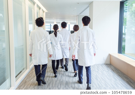 The backs of doctors walking in a hospital hallway 105478659