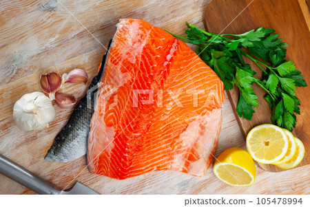 Raw red fish salmon fillet, lemon, parsley 105478994