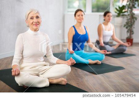 Elderly woman doing yoga in fitness studio Elderly woman doing yoga in fitness studio 105479454
