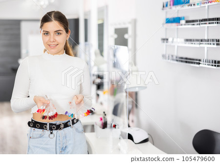 Portrait of a manicurist with a palette with color schemes of nail polish 105479600