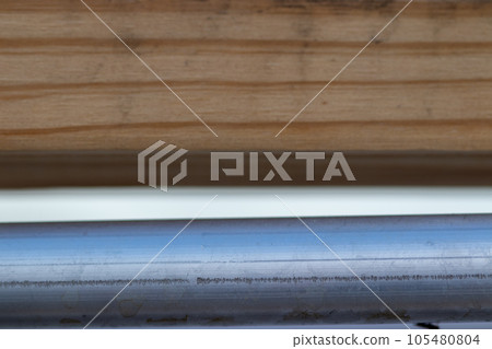 close up of metal pipe tube and wood background close up of metal pipe tube and wood background 105480804