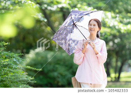 帶著遮陽傘行走的高級女人 105482333