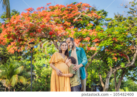 A loving family enjoying a leisurely walk in the park - a radiant pregnant woman after 40, embraced by her husband, and accompanied by their adult teenage son, savoring precious moments together A loving family enjoying a leisurely walk in the park - a radiant pregnant woman after 40, embraced by her husband, and accompanied by their adult teenage son, savoring precious moments together 105482400
