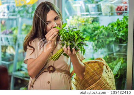 A glowing pregnant woman after forty makes a healthy choice as she selects organic vegetables and fruits at the vibrant organic market, prioritizing her well-being and her baby's health A glowing pregnant woman after forty makes a healthy choice as she selects organic vegetables and fruits at the vibrant organic market, prioritizing her well-being and her baby's health 105482410