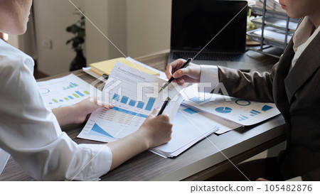 Chief and employee discuss monthly earning graph together in the office 105482876