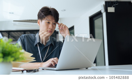 Tired stressed office worker sitting at desk and thinking, he is rubbing his eyes and feeling exhausted Tired stressed office worker sitting at desk and thinking, he is rubbing his eyes and feeling exhausted 105482888