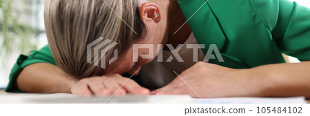 Exhausted and tired woman sleeping on her desk in office. Exhausted and tired woman sleeping on her desk in office. 105484102