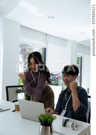 Success of happy employees smiling and laughing to celebrate project success in office 105484121