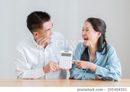 Senior couple with a calculator (retirement, money, savings) Senior couple with a calculator (retirement, money, savings) 105484501