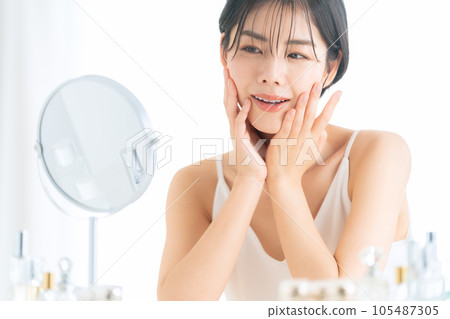 Short hair young woman doing skin care in makeup room 105487305