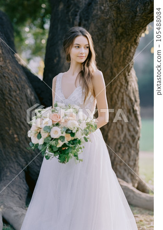Beautiful bride with a bouquet of white and pink roses 105488084