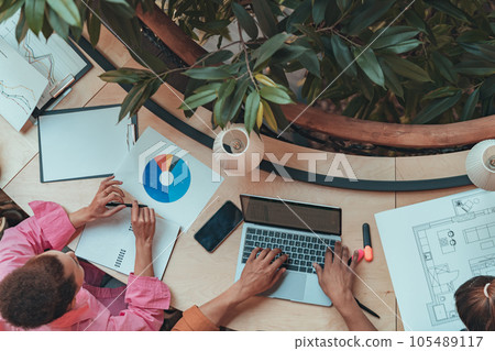 Top view of coworkers working together at modern office. Workplace and cooperation concept Top view of coworkers working together at modern office. Workplace and cooperation concept 105489117