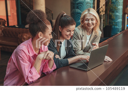Friendly diverse business people laughing working on project together in modern coworking Friendly diverse business people laughing working on project together in modern coworking 105489119