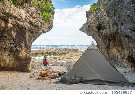 camping solo camp one person camp tent setup sea seaside bonfire rocky place copy space 105489937
